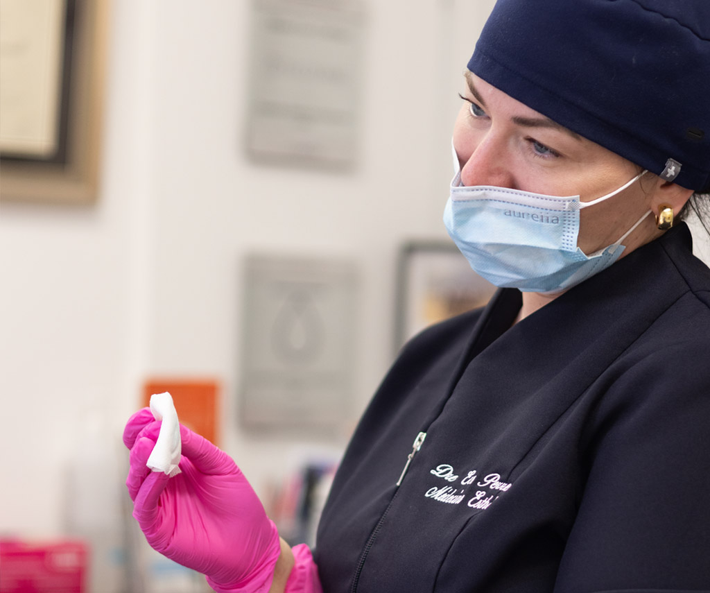 Professionnelle portant un masque pendant un soin à la clinique.